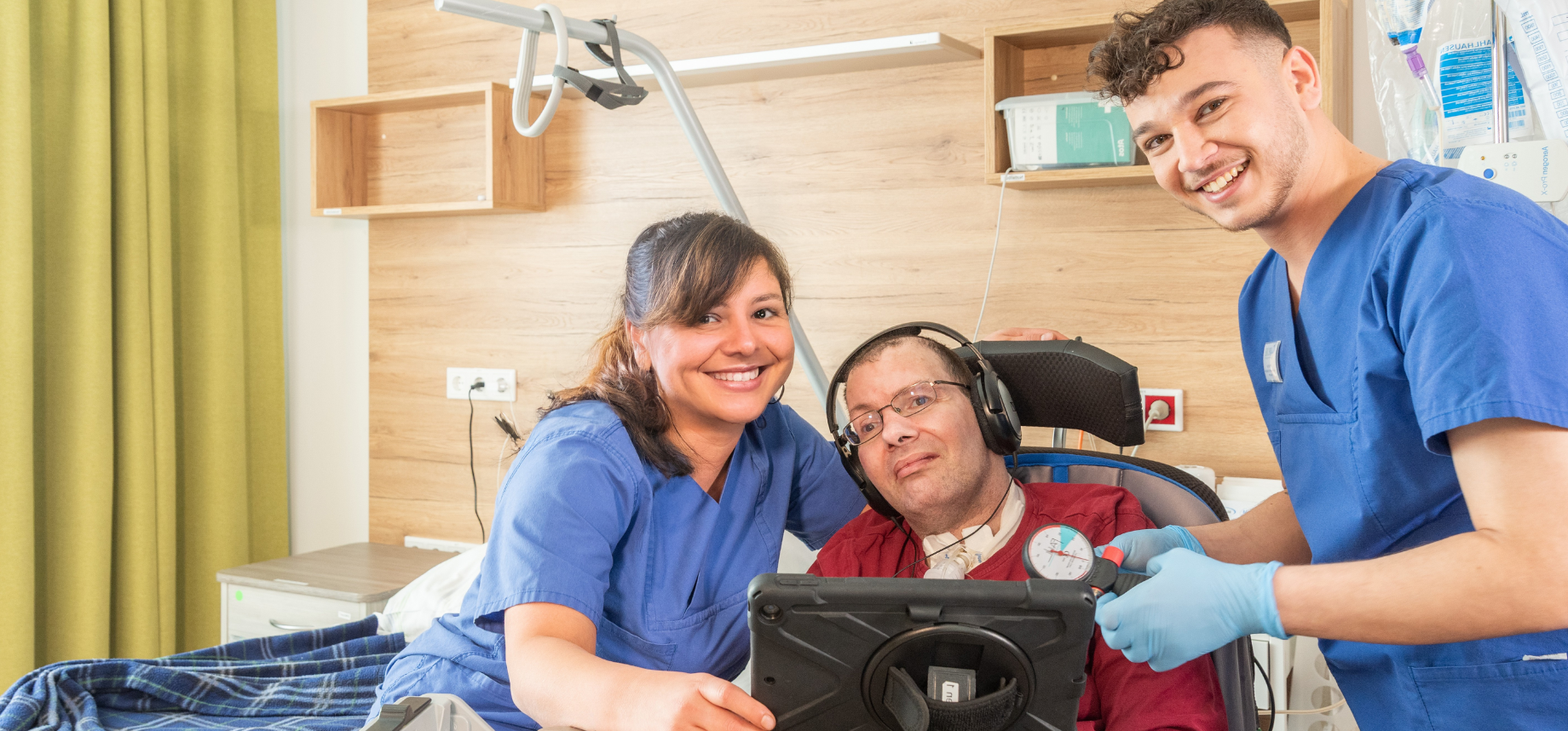 Pflegepersonal mit Patient in einem Zimmer der Intensivpflege WG